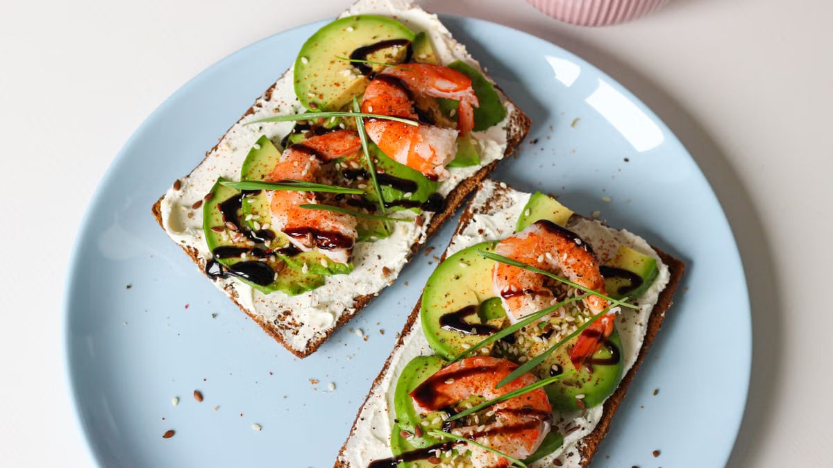 Delicious shrimp avocado toast with cream cheese on rye bread, perfect for brunch.